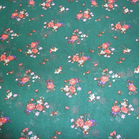 Fabric with pink, red, and fuchsia floral pattern on a forest green background - Picture 1 of 3